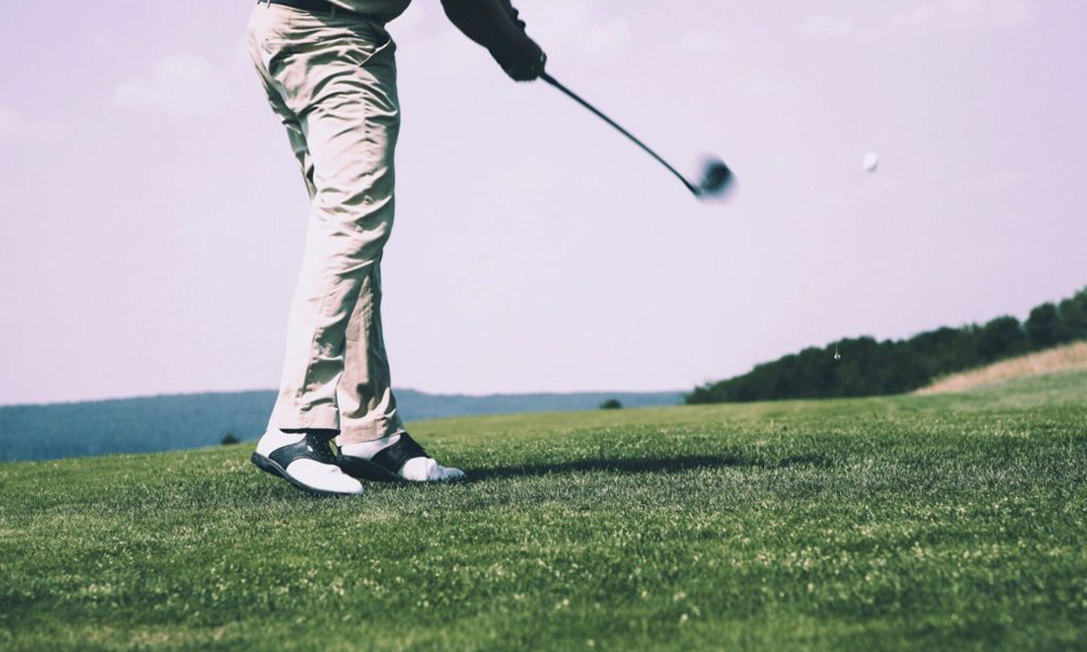 Golfer following through on a swing on a golf course